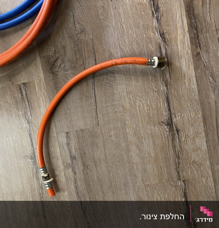 צינור כתום עם מחבר מתכת על רצפה